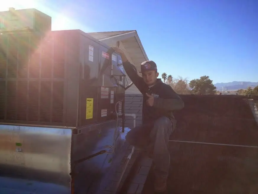 HVAC technician performing HVAC Inspection on a rooftop unit in Raleigh Hills